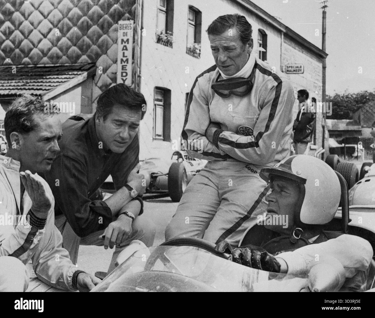 Le pilote automobile Phil Hill, le réalisateur John Frankenheimer, les acteurs Yves Montand et James Garner sur le tournage du film Grand Prix, USA 1966 Banque D'Images