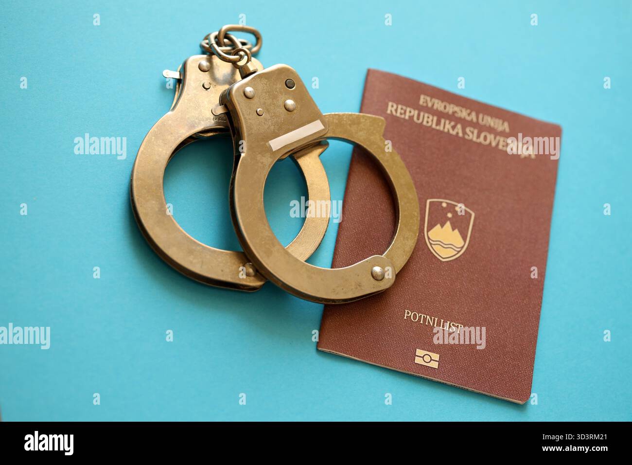 Passeport slovène avec menottes de police sur la table de près. Niveau de criminalité et arrestations en Europe concept Banque D'Images