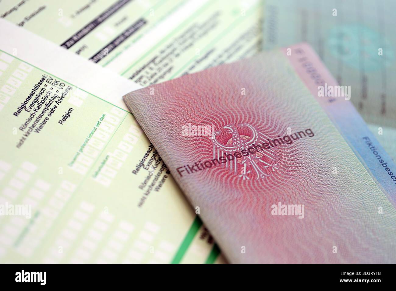 Le spécimen de carte de résident permanent temporaire allemand se trouve sur le formulaire fiscal allemand close up. Fiktionsbescheinigung et einkommensteuerklarung Banque D'Images