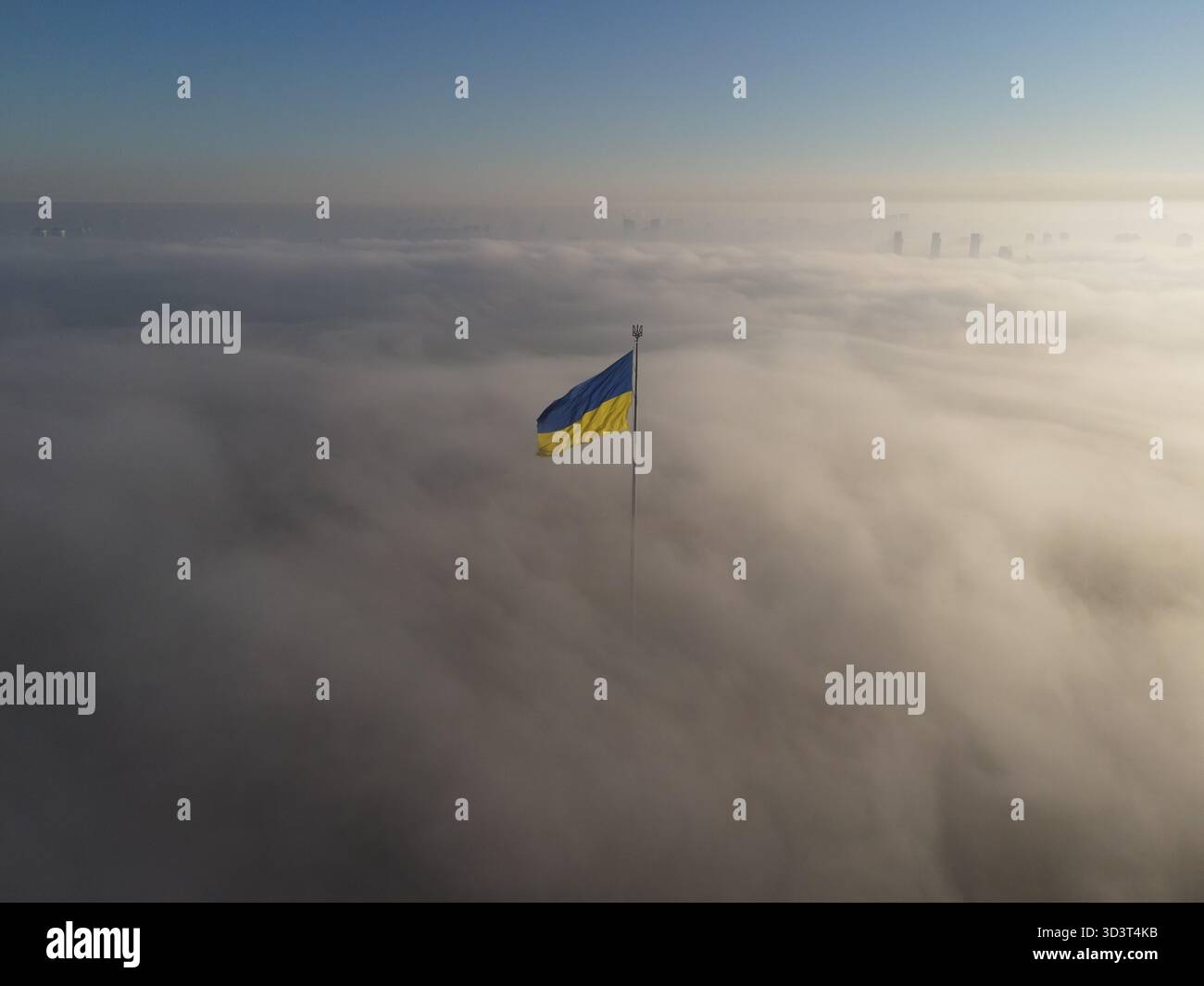 Drapeau national ukrainien volant au-dessus des nuages un matin brumeux à Kiev, Ukraine. Vue aérienne par drone. Banque D'Images