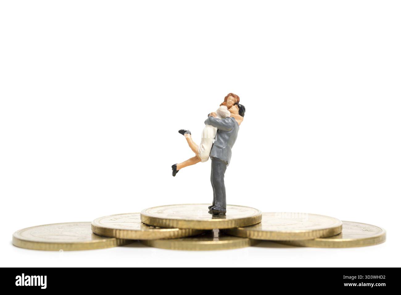 Personnages miniatures : couple serrant debout sur la pile de pièces de monnaie, de l'argent et des concepts financiers Banque D'Images