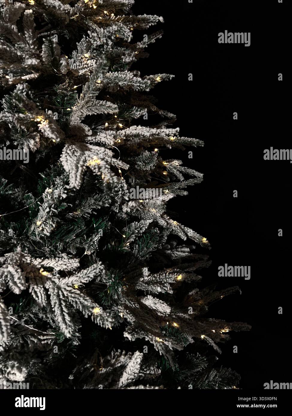 Arbre de Noël artificiel dans la neige avec des lumières jaunes - Image de stock capturée avec un smartphone