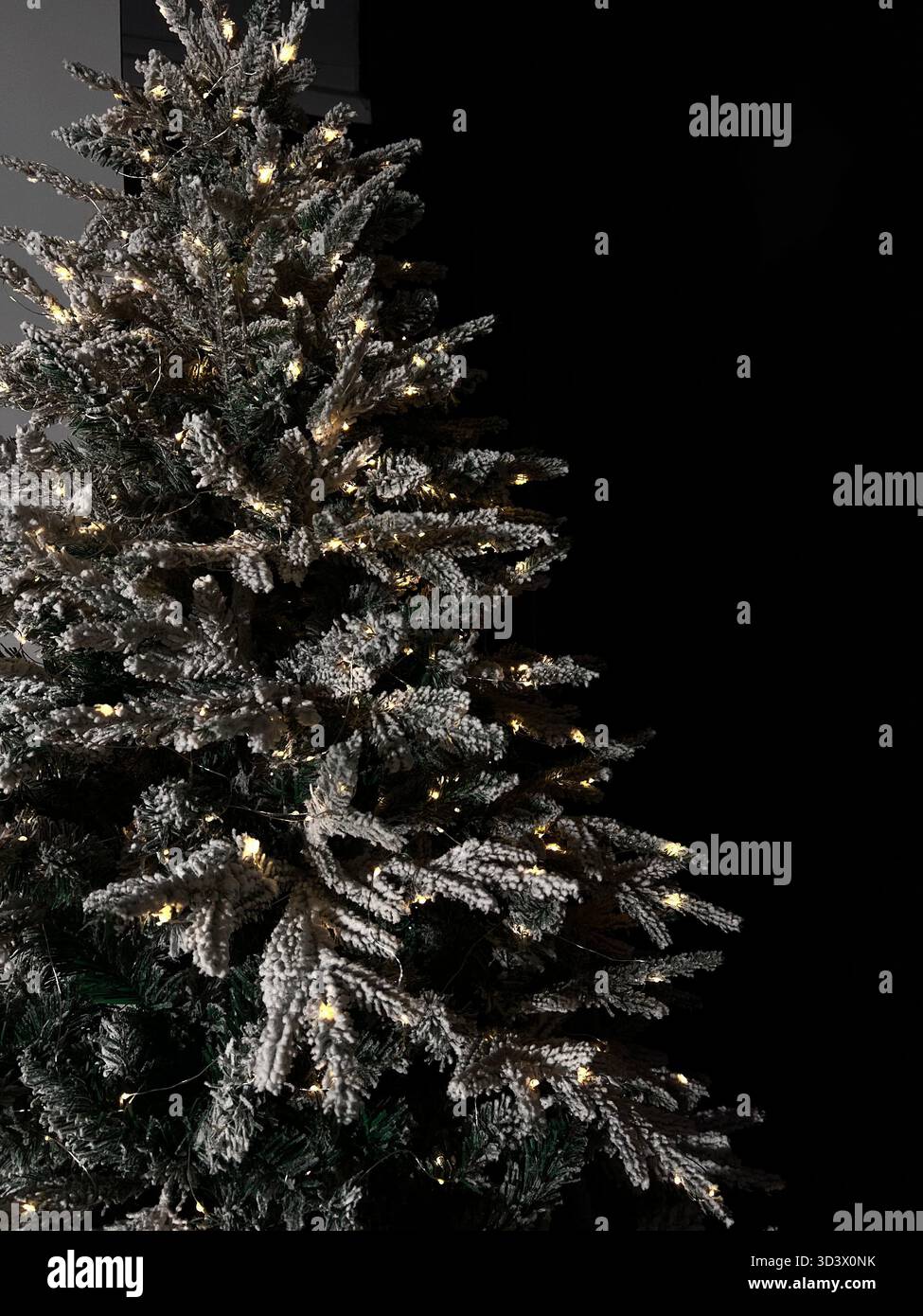 Arbre de Noël artificiel dans la neige avec des lumières jaunes - Image de stock capturée avec un smartphone