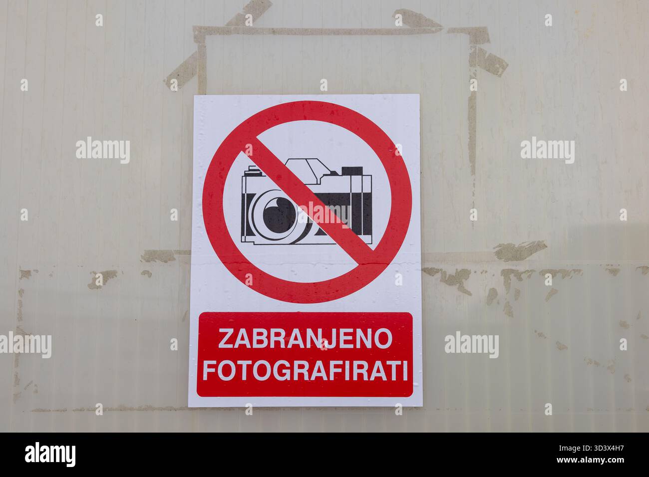 Panneau audacieux sans photographie monté sur un mur pâle avec un cercle d'interdiction rouge sur une icône d'appareil photo, signalant les restrictions de confidentialité et de photographie Banque D'Images
