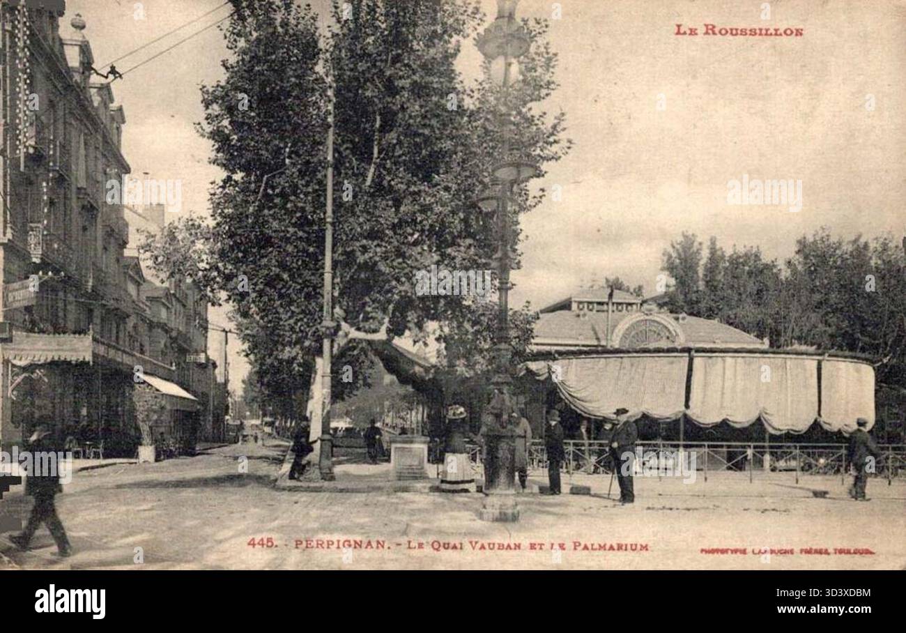 Cette image de Perpignan montre Quai Vauban et Café le Palmarium. Le café est situé le long du front de mer, offrant un cadre pittoresque au cœur de la ville. Banque D'Images