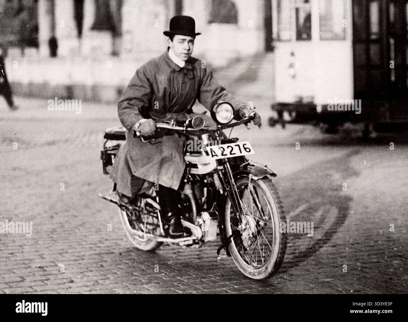 Le prince héritier Gustav Adolf de Suède, vêtu d'un imperméable et d'un chapeau melon, conduit une moto dans les rues de Stockholm, capturé en 1922. Banque D'Images