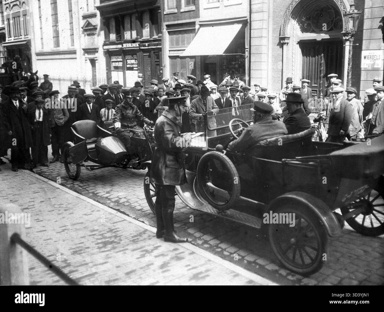 Une opération de contrôle de la circulation menée par la brigade moto de la police d'Amsterdam en 1921, montrant le rôle des forces de l'ordre dans la gestion de la circulation urbaine. Banque D'Images