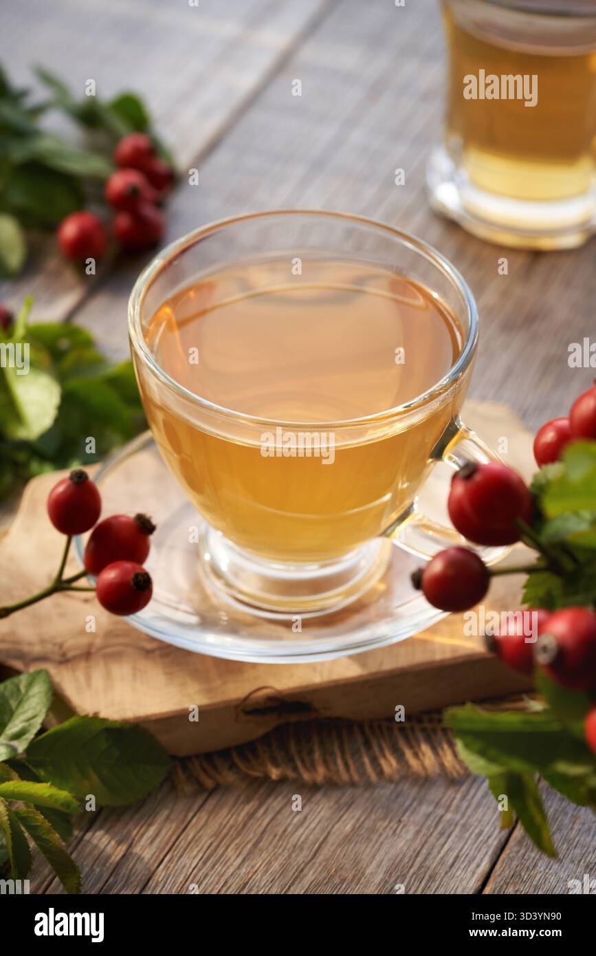 Une tasse de thé rose hip sur une table en bois Banque D'Images