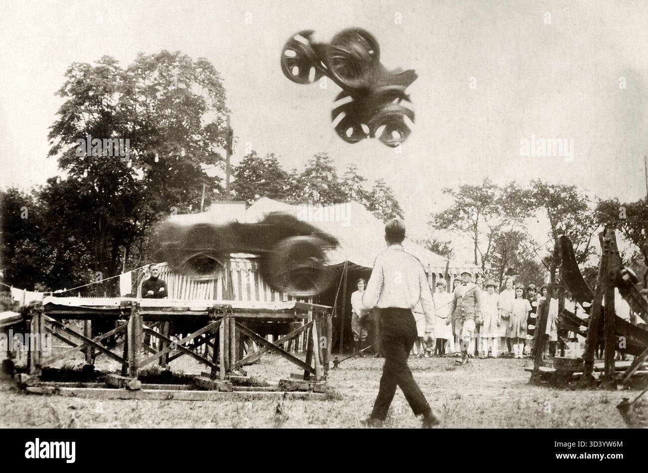 Cette image de 1924 capture le moment où les sœurs casse-tête Belly et Peggy Gregg exécutent simultanément leur saumon somnolent en plein air au Woodlandpark, Trenton, New York. Les voitures sont vues en vol dans le cadre de leur cascades. Banque D'Images