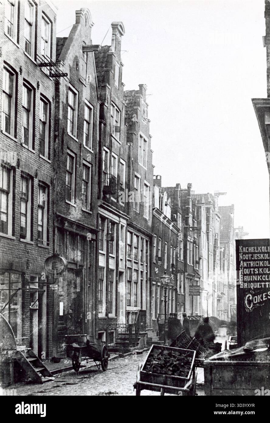 Une scène de rue dans le centre d'Amsterdam montrant des chariots à main dans une entreprise de commerce de charbon au début du 20ème siècle. Banque D'Images