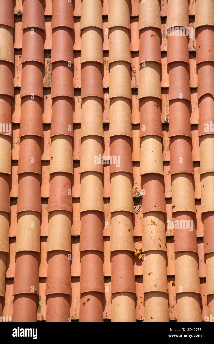 Vue rapprochée des tuiles traditionnelles en argile. Les rangées de terre cuite rouge et orange créent un motif texturé et un fond d'architecte méditerranéen Banque D'Images