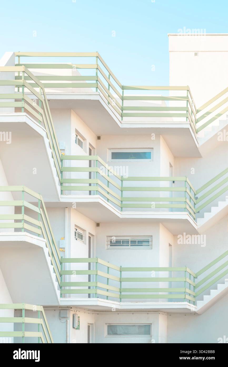 Composition géométrique des escaliers et des balcons à l'extérieur d'un bâtiment moderne blanc avec des garde-corps vert pastel Banque D'Images
