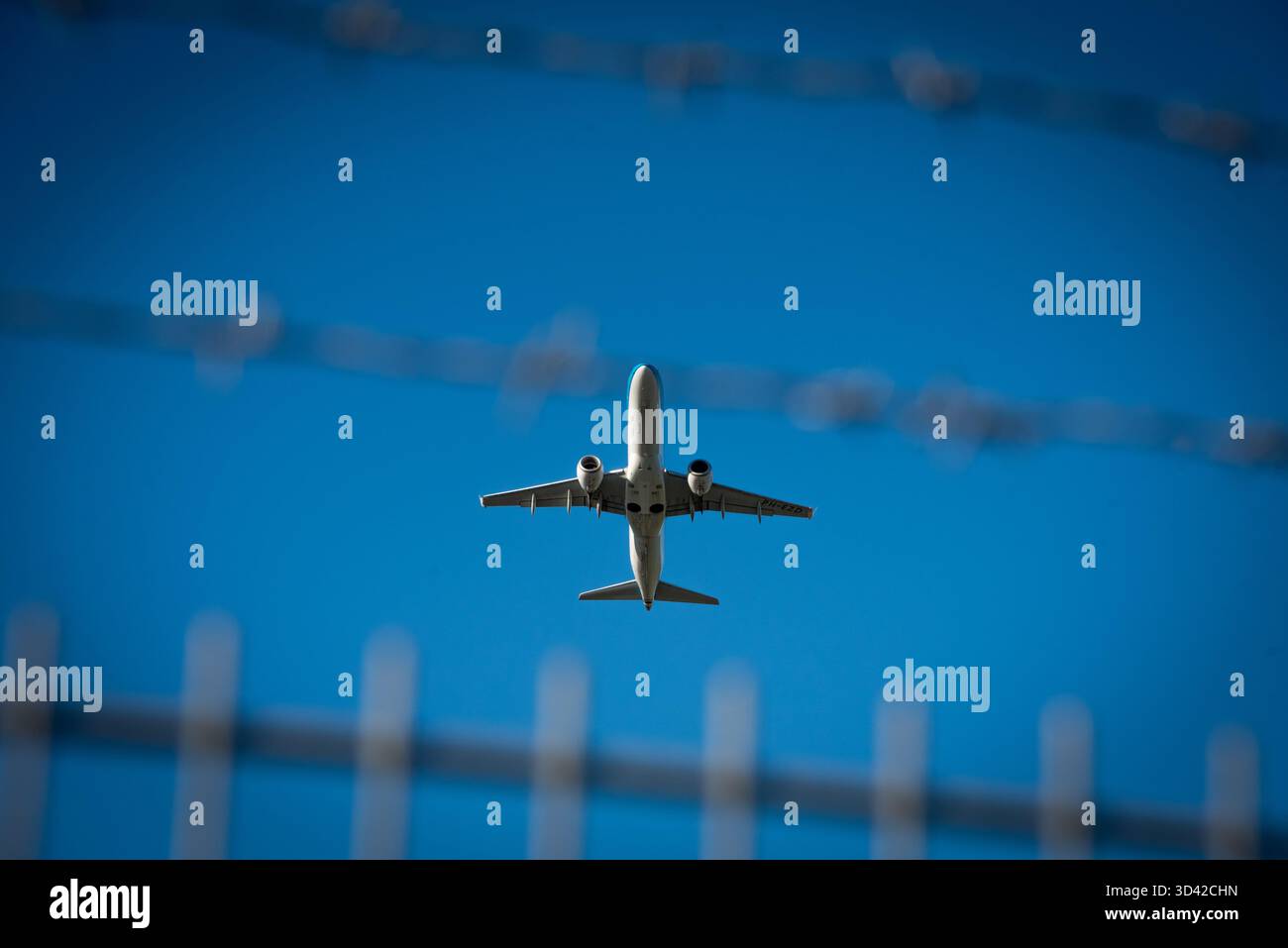 Hambourg, Allemagne, 7 septembre 2025 : avion derrière une barrière de fil barbelé pendant le décollage à l'aéroport de Hambourg Banque D'Images