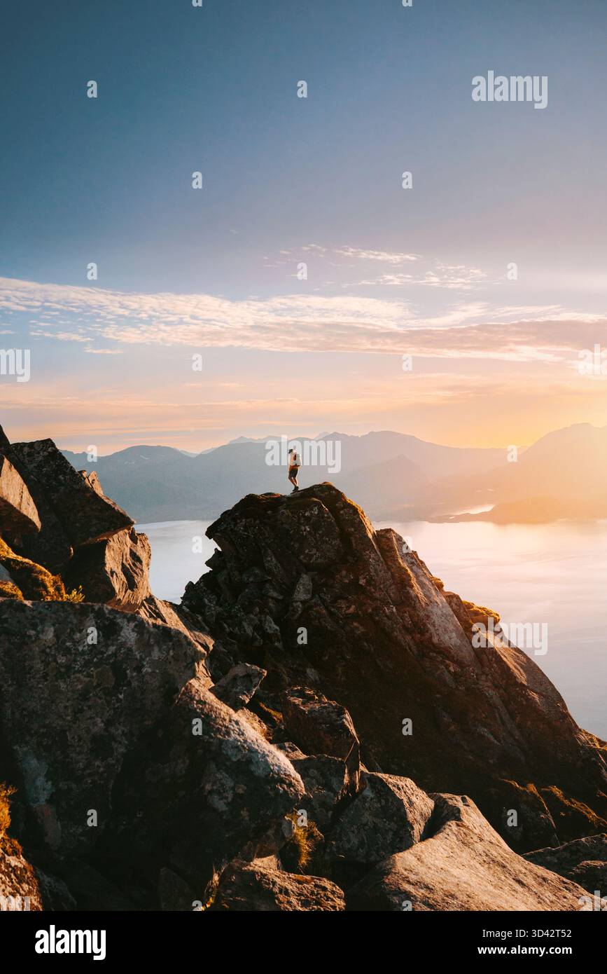 Homme grimpeur debout sur le bord de falaise rocheuse de montagne en Norvège voyage seul dans les îles Lofoten, expédition d'alpinisme aventure randonnée tour d'été ext Banque D'Images