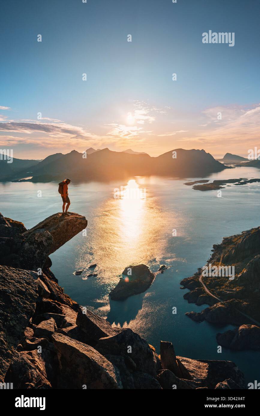 Homme découverte touristique Norvège en solo debout sur le bord de la falaise Torsketunga voyage dans les îles Lofoten escalade des montagnes au-dessus de la mer, extrême aventure tour hi Banque D'Images