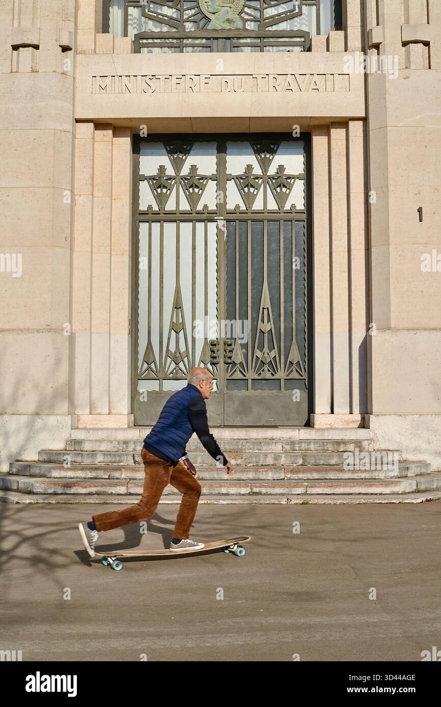 Skateboard Man glisse devant le ministère du travail à Paris par une journée ensoleillée, Paris, France Banque D'Images