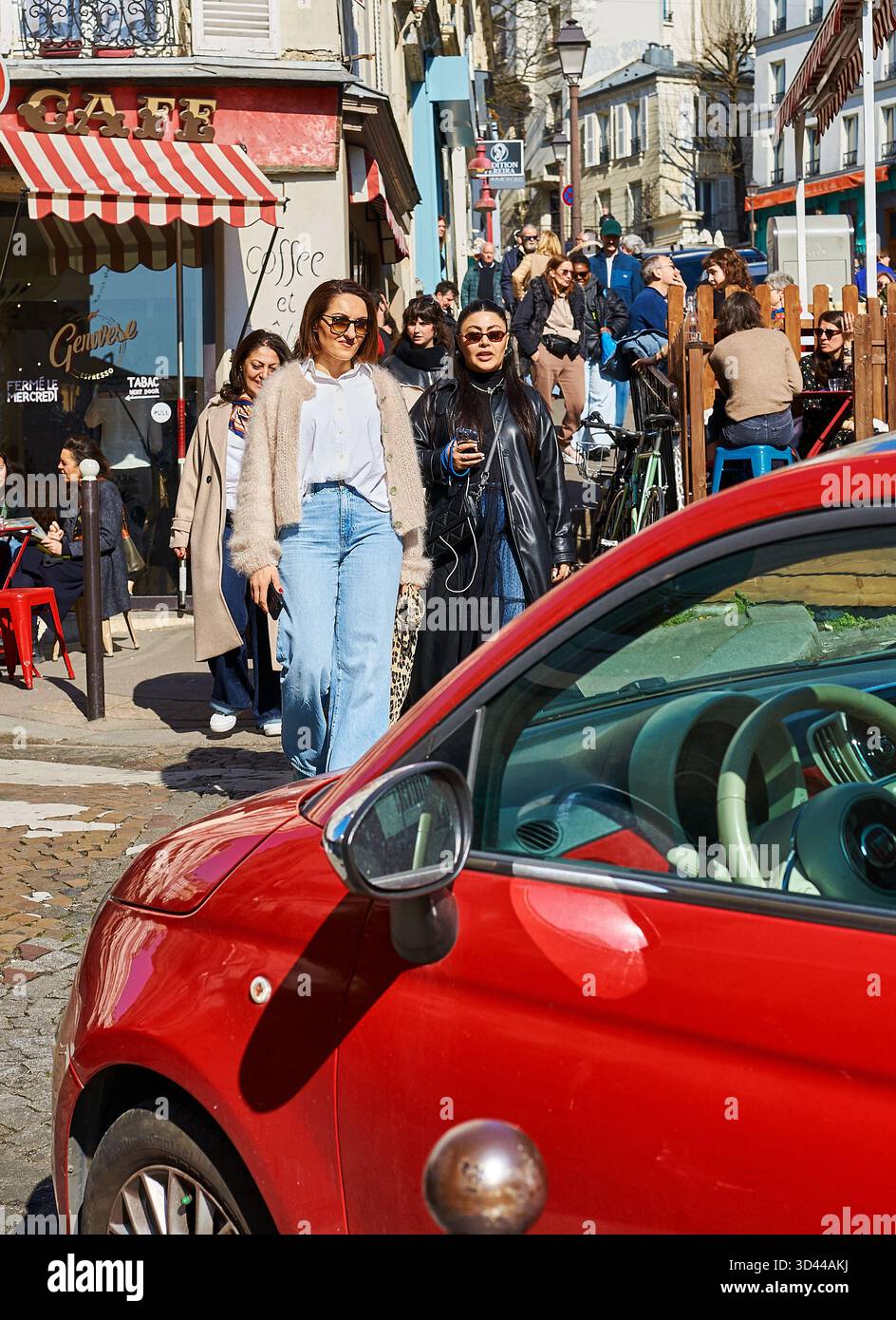Visiteurs profitant d'une journée ensoleillée à Montmartre, Paris, entouré par la culture des cafés et la vie de rue, Paris, France Banque D'Images