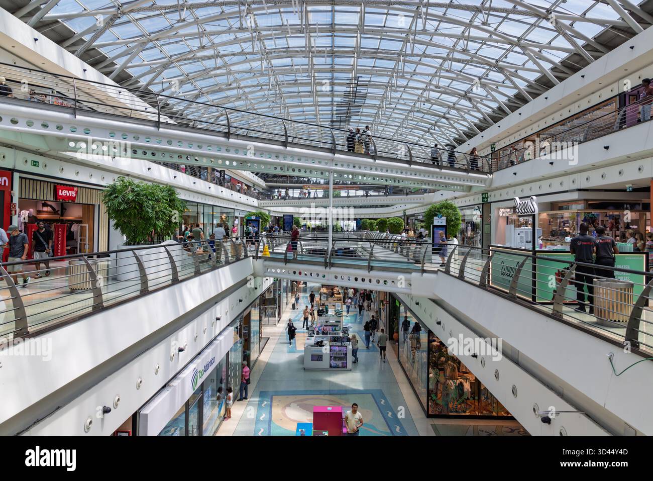 Intérieur dynamique et à plusieurs niveaux du centre commercial Centro Vasco da Gama à Lisbonne, avec un toit en verre lumineux et une activité commerciale animée. Lisbonne, Banque D'Images