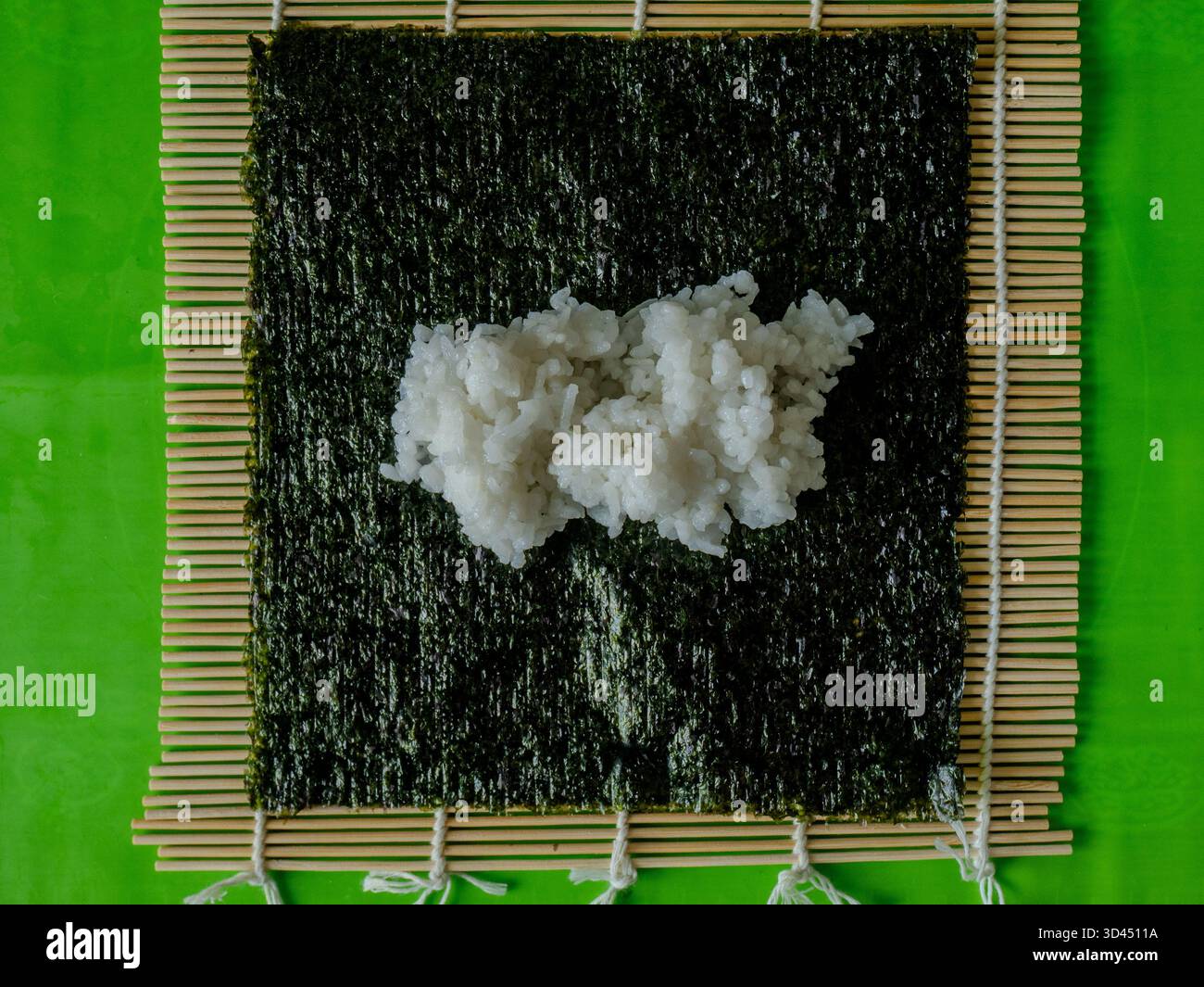 Vue de dessus du riz Sushi réparti uniformément sur feuille de Nori et tapis de bambou, photo de préparation de cuisine japonaise pour les créateurs de cuisine et de cuisine. Haute qualité p Banque D'Images