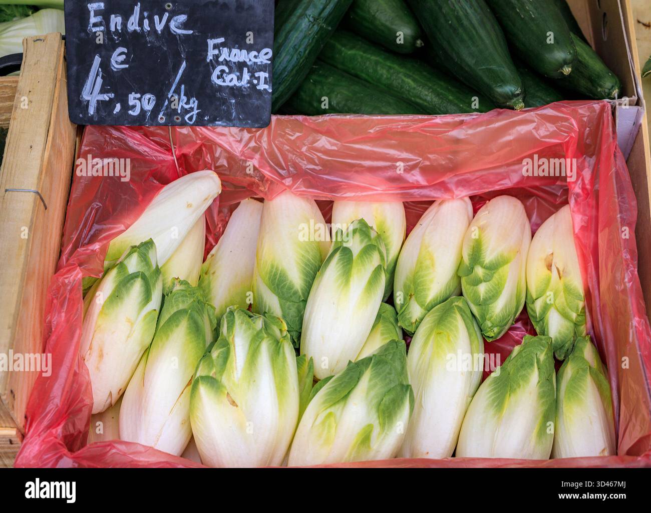 Endive belge blanche aux pointes vertes dans un stand de légumes du marché paysan provençal du cours Saleya dans la vieille ville de Nice, dans le sud de la France Banque D'Images