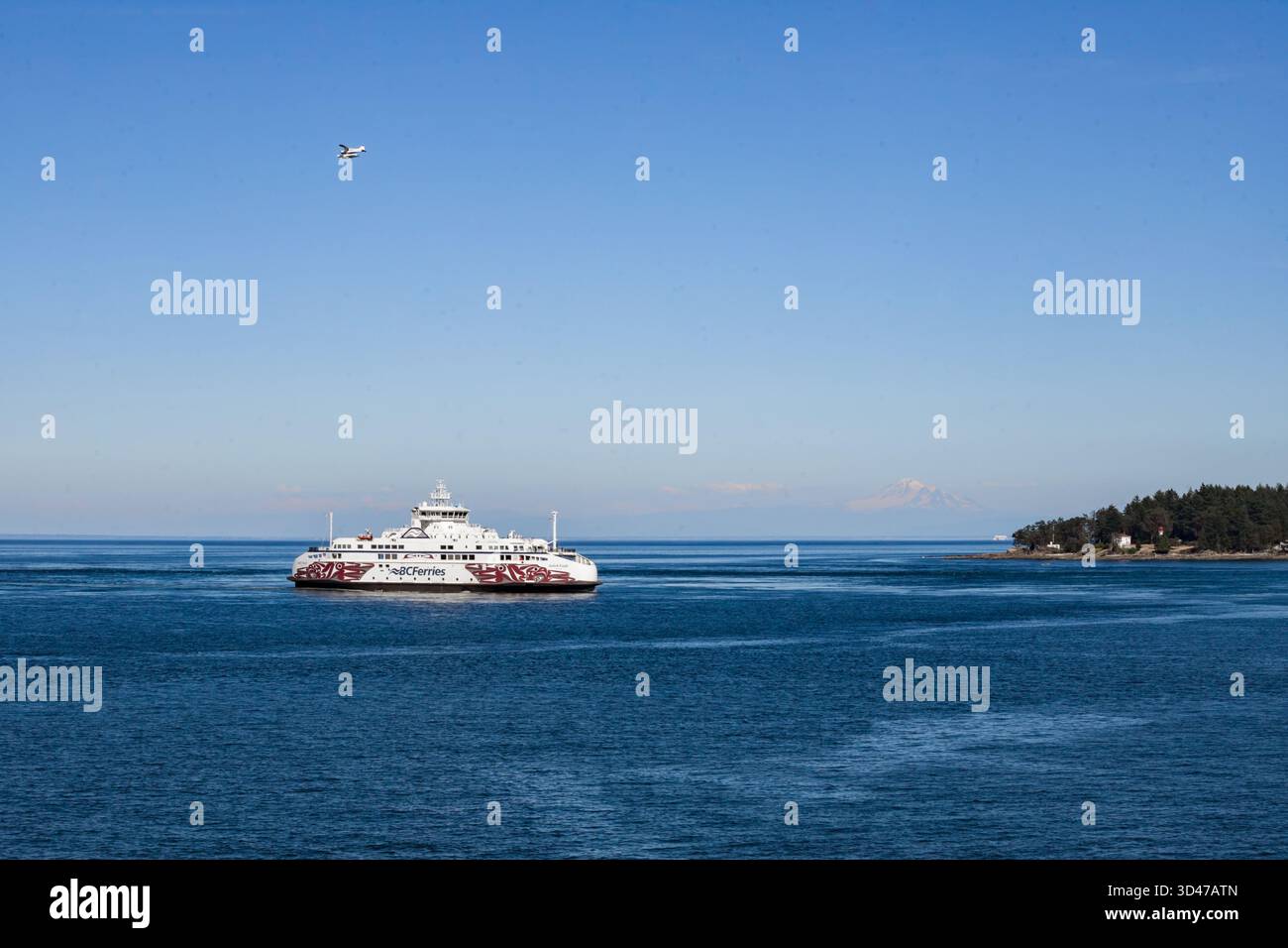 White Ferry de Vancouver à l'île de Vancouver navigue dans les eaux calmes de la baie. Le mont Baker est visible en arrière-plan. Banque D'Images