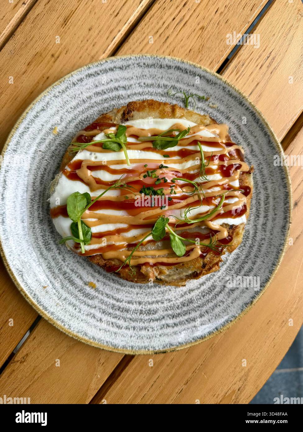 Hiroshima style okonomiyaki avec des œufs au plat pour le petit déjeuner aussi de la nourriture de rue Banque D'Images