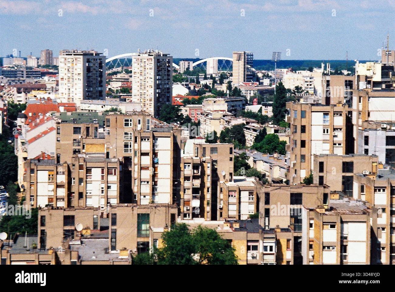 Instantané analogique de style brutaliste de Novi Sad avec le pont Žeželj distant à l'horizon, la géométrie en béton ensoleillé et les lignes urbaines claires. Banque D'Images