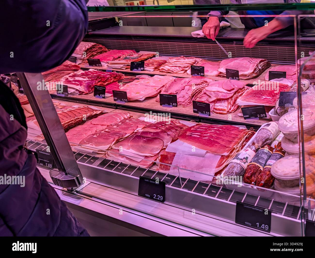 Au comptoir Delicatessen dans le supermarché, le client choisit parmi diverses coupes à froid, jambon, bacon et salami. Banque D'Images