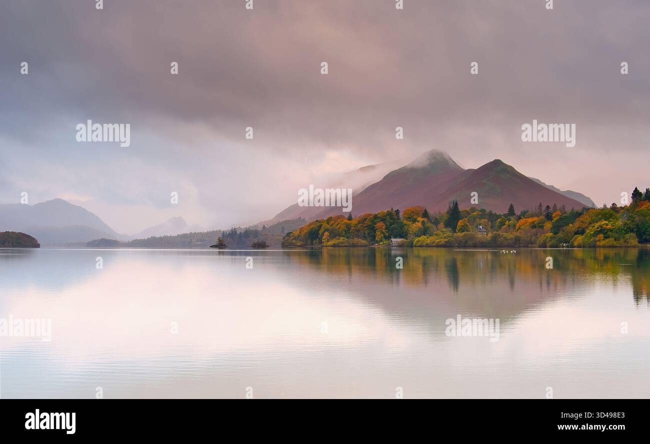 L'aube d'un matin d'automne brumeux donne au nuage bas une douce teinte rose alors qu'il entoure le sommet de Cat Bells. Banque D'Images