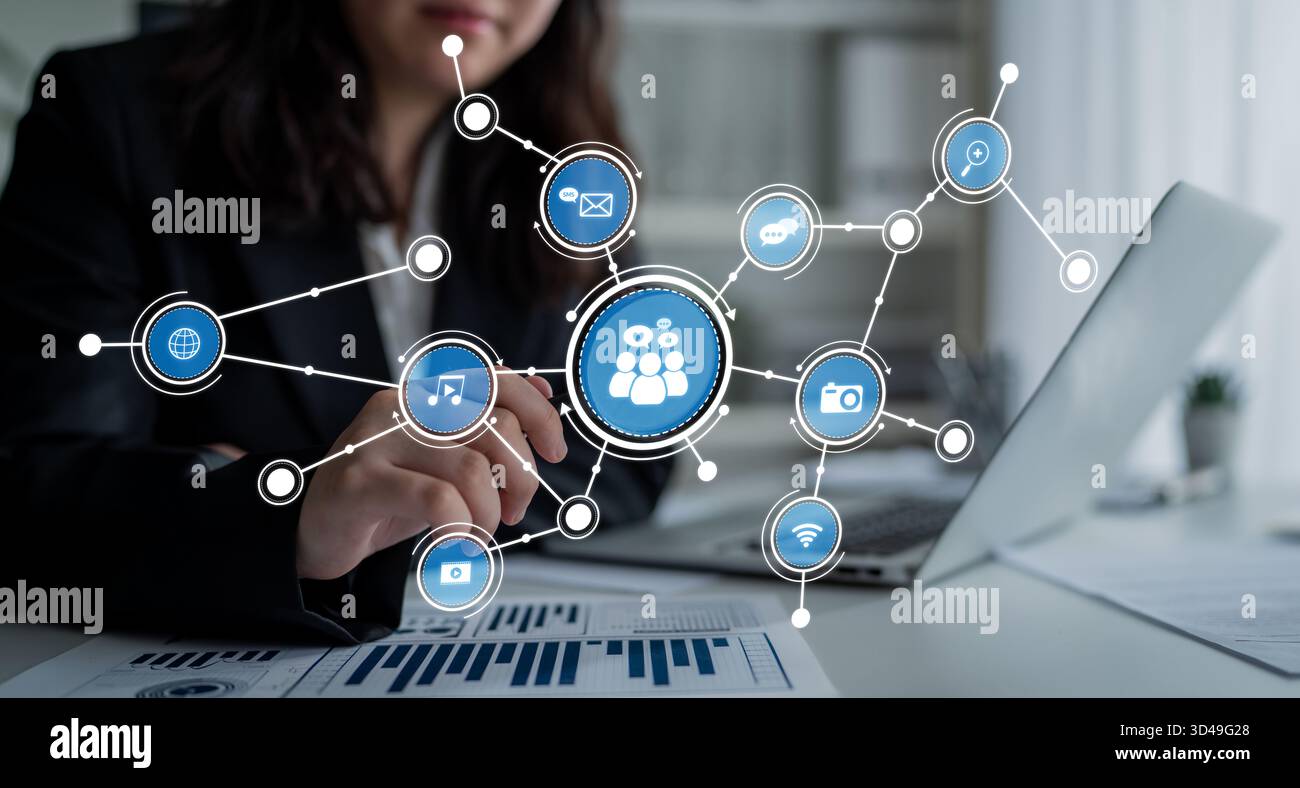 Une femme d'affaires interagit avec un ordinateur portable, présentant un concept dynamique de réseau de médias sociaux avec des icônes représentant divers canaux de communication et Banque D'Images