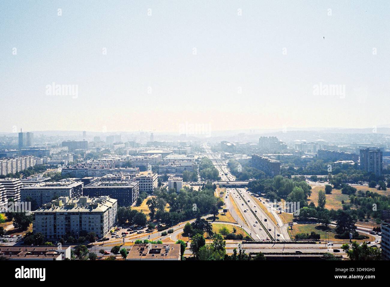 Vue à travers la fenêtre Genex Tower surplombant Belgrade par une journée ensoleillée, tons analogiques avec ciel clair et paysage urbain. Banque D'Images