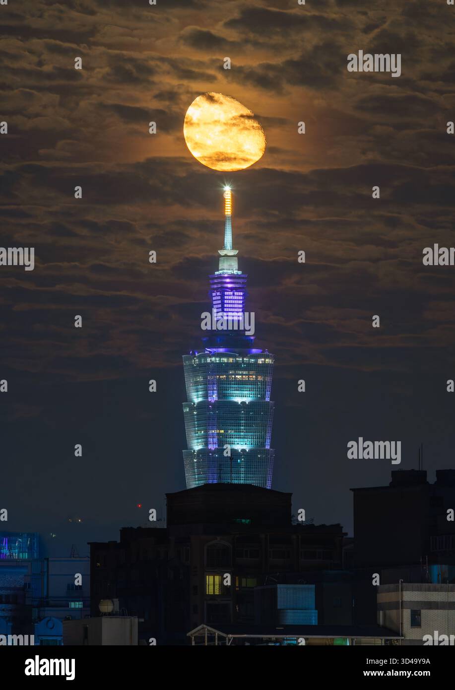 Sanchong, Taiwan - 15 juin 2025 : une scène nocturne époustouflante mettant en vedette la tour illuminée Taipei 101 avec un croissant de lune se levant derrière elle. Allumé Banque D'Images