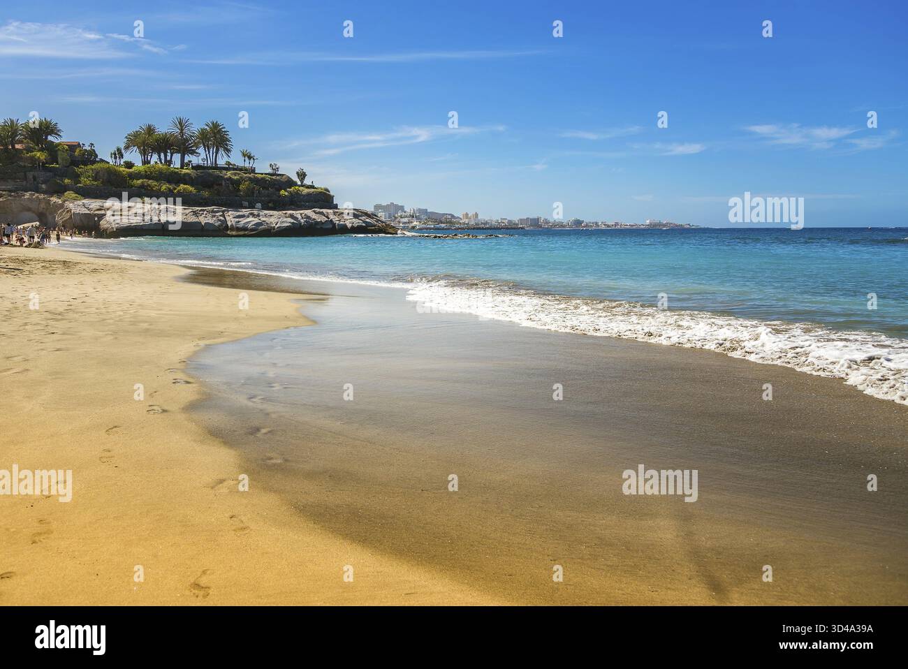 Les vagues douces de Playa Del Duque à Tenerife reflètent des nuances de turquoise et de bleu lorsqu’elles se touchent au rivage sablonneux. Cette plage sereine offre un Banque D'Images