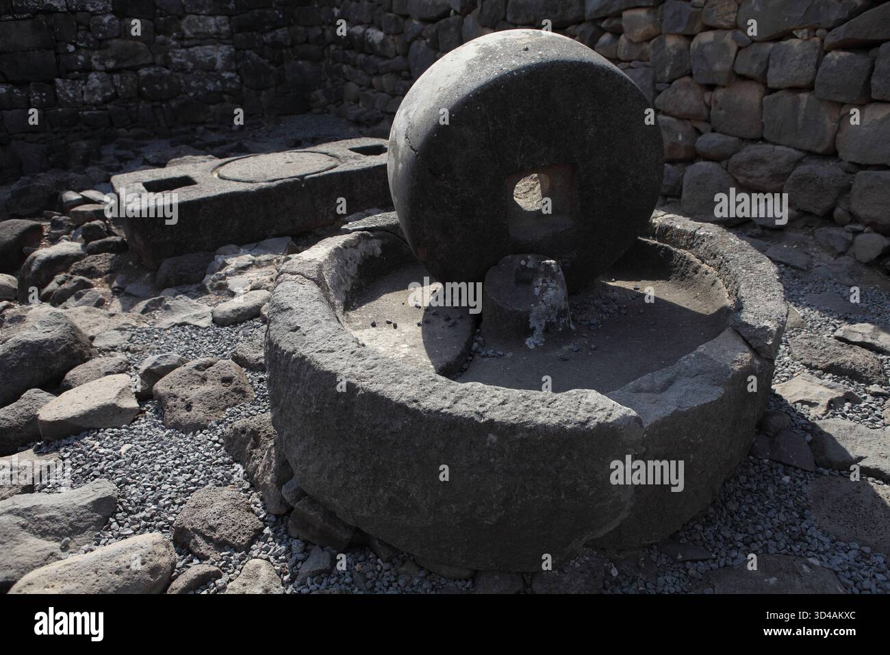 Ancienne roche basaltique huile d'olive presser, les olives ont été mises sur la pierre ronde inférieure pour être écrasées par la pierre supérieure tournée par un âne pour presser l'huile. Banque D'Images