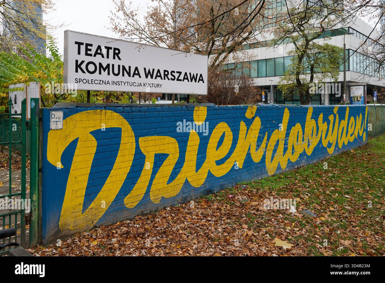 Panneau du théâtre Komuna Warszawa - institution sociale de la culture à la rue Emilii Plater, avec la murale disant « Bonjour » en dessous. Banque D'Images