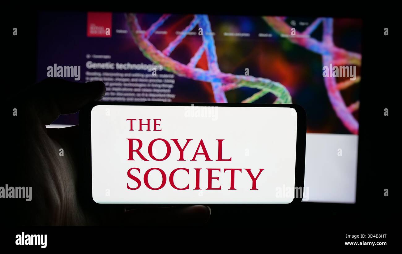 Stuttgart, Allemagne - 11-01-2025 : personne tenant un téléphone portable avec le logo de l'organisation britannique Royal Society sur l'écran en face de la page web. Banque D'Images