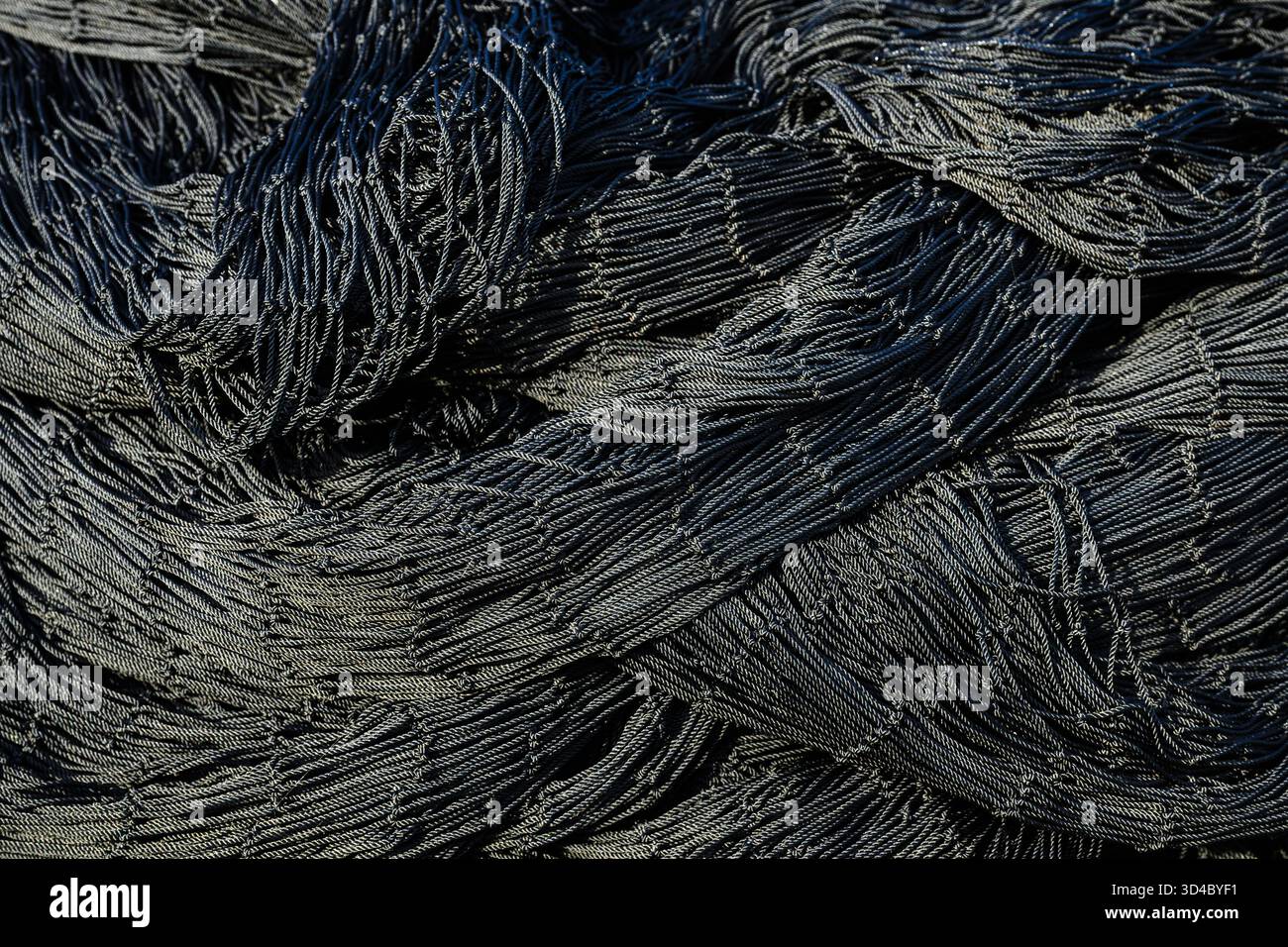 Gros plan abstrait modèle de détail dans le filet de pêche commerciale industriel noir Banque D'Images