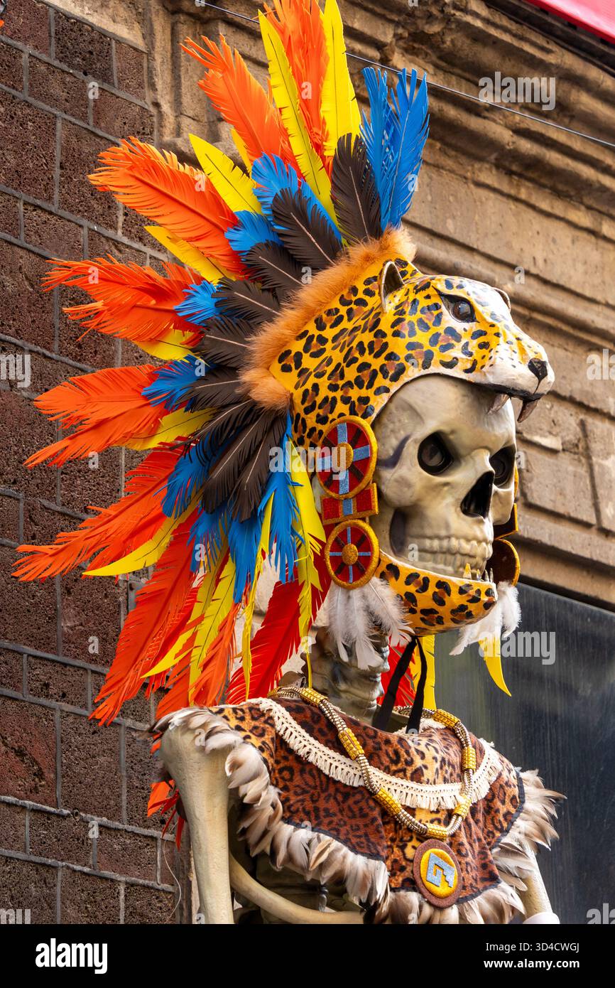 Un squelette portant une coiffe indienne colorée. Le squelette porte un masque imprimé léopard. Fête mexicaine de la tradition des morts, offrandes, nourriture, colo Banque D'Images