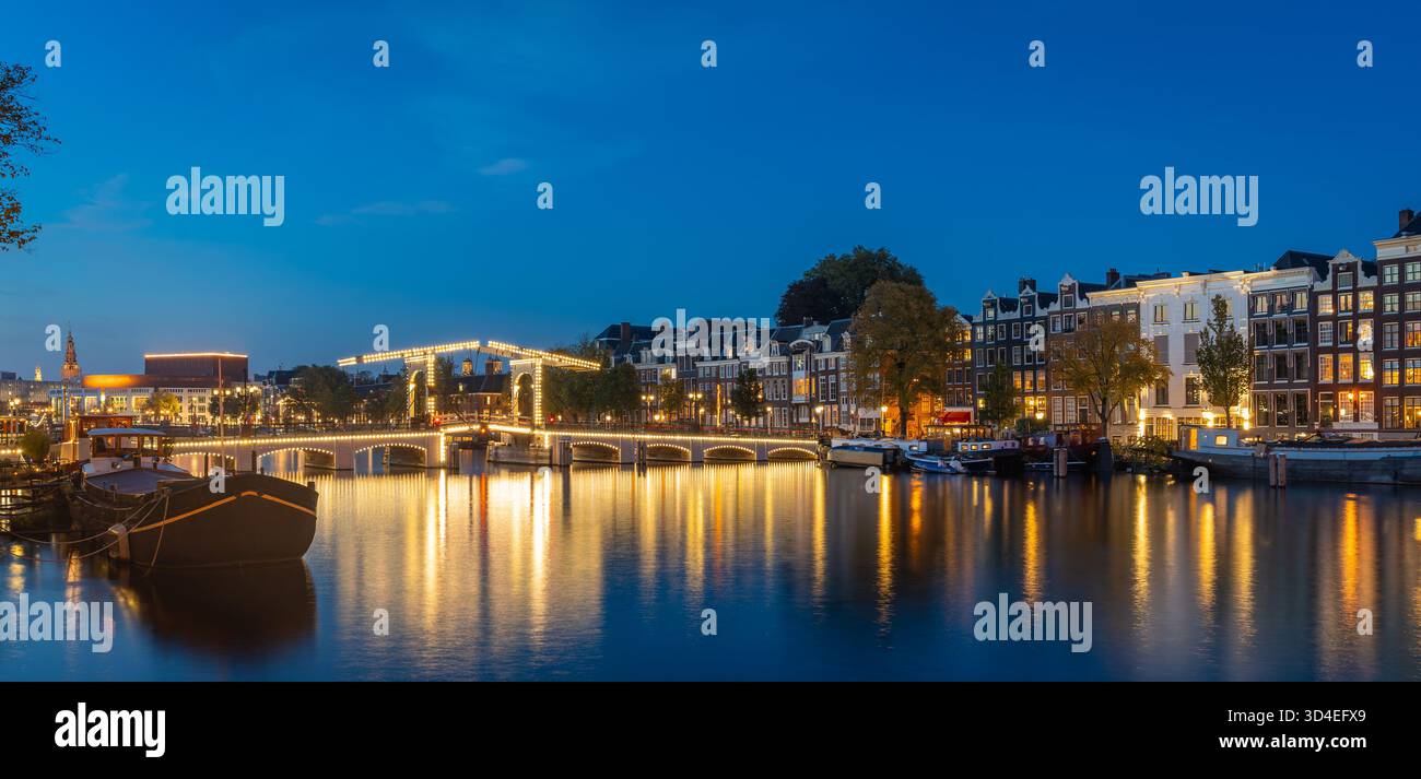 Panorama d'Amsterdam à l'heure bleue, maisons historiques et Magere Brug (Pont maigre) reflété dans la rivière Amstel Banque D'Images