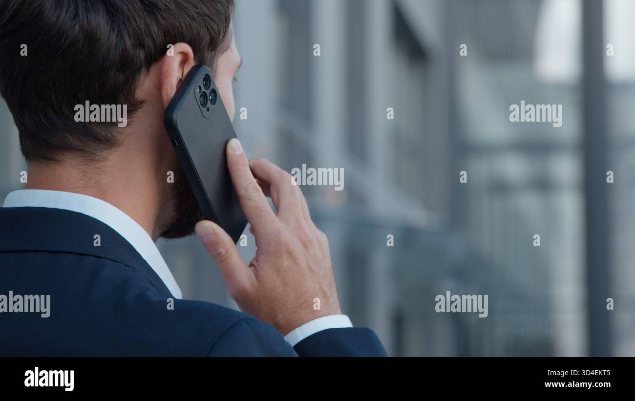 Vue arrière méconnaissable homme d'affaires caucasien parlant téléphone d'affaires appeler homme parlant discussion homme mobile appel dans la ville professionnel inconnu Banque D'Images
