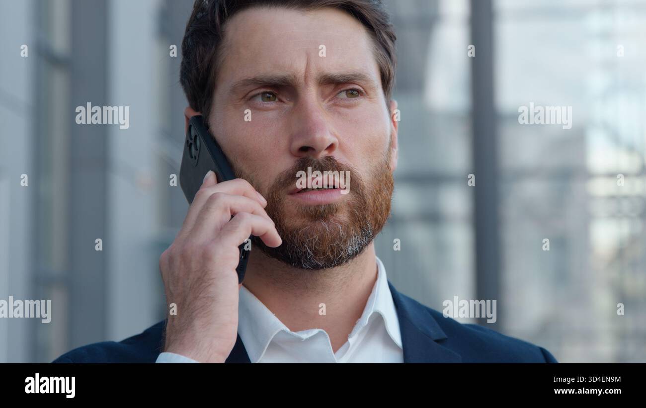 Sérieux homme d'affaires mature caucasien parlant téléphone répondant à l'appel formel dans la ville homme d'affaires d'âge moyen chef de projet de démarrage masculin chef de projet Banque D'Images