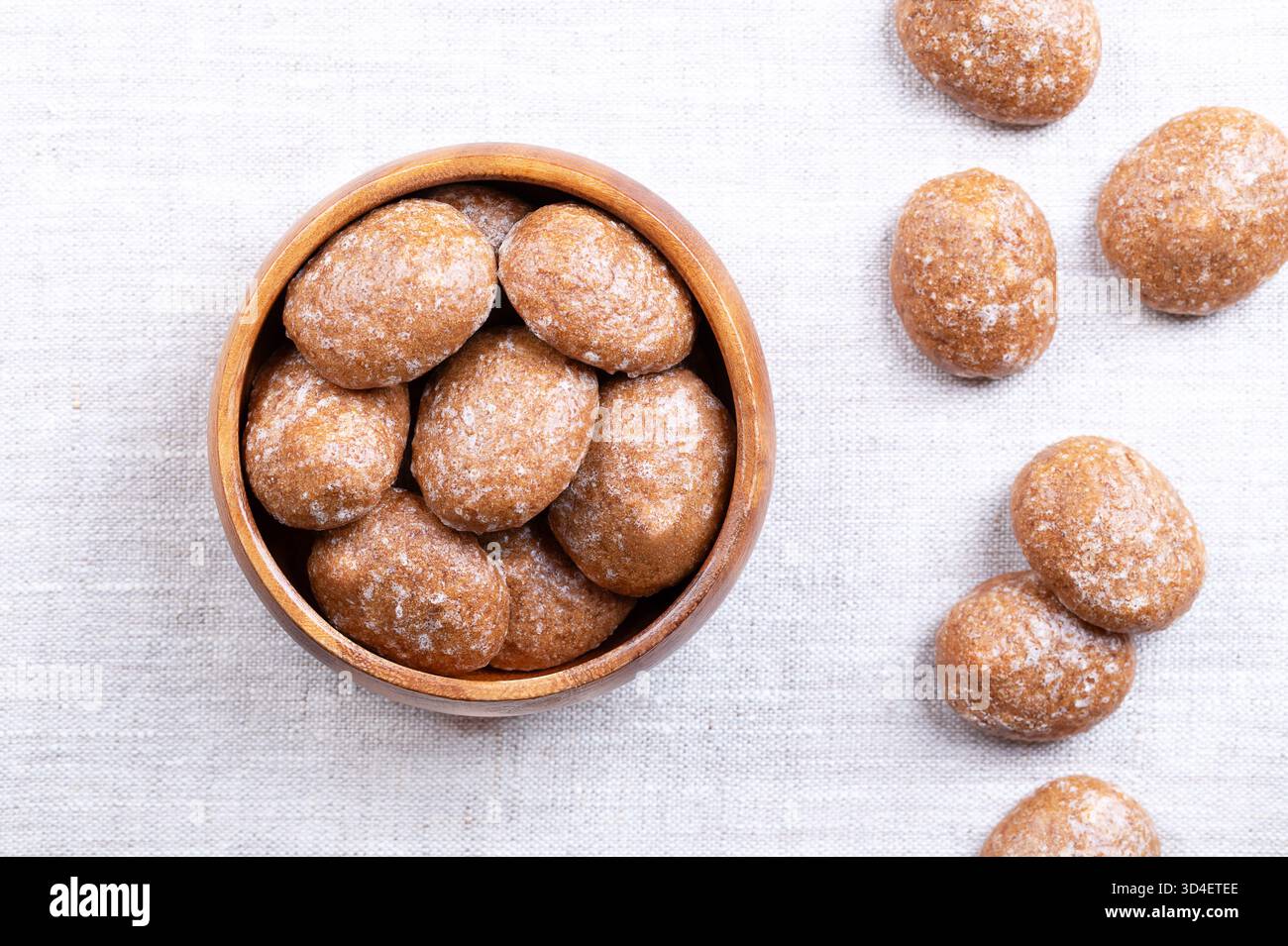 Biscuits au pain d'épices, biscuits de Noël glacés au sucre, dans un bol en bois, sur du lin. Biscuits aux épices. Banque D'Images
