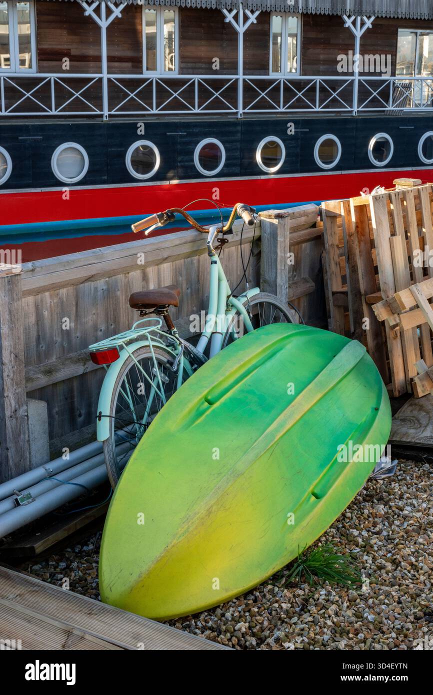Kayak en plastique et vélo vintage à l'extérieur d'une péniche aménagée sur la côte de l'île de wight au Royaume-Uni au port de Bembridge. Style de vie hors réseau. Banque D'Images