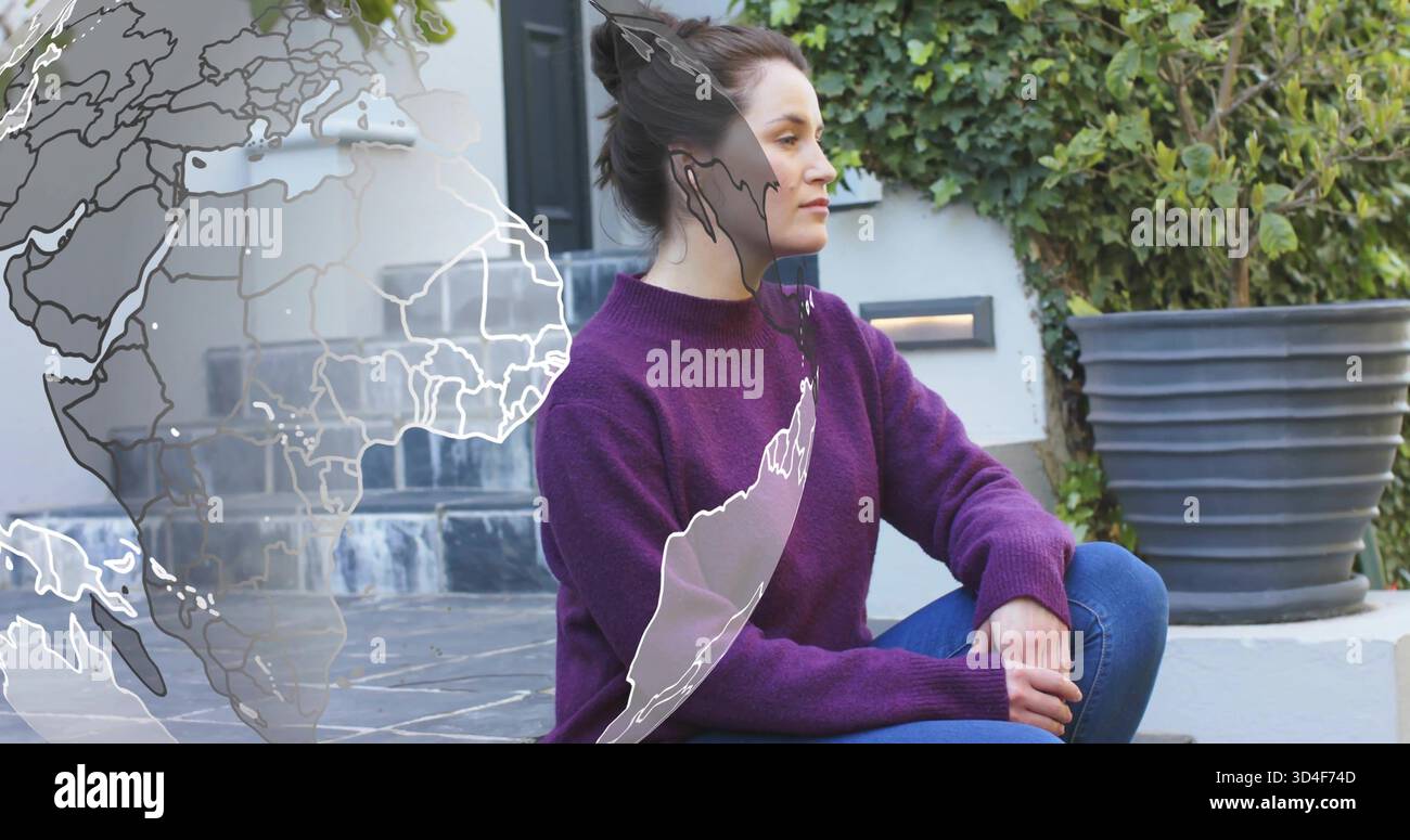 Femme assise portant un pull violet et un Jean sur des marches carrelées, avec recouvrement de globe, jardinière et lierre Banque D'Images