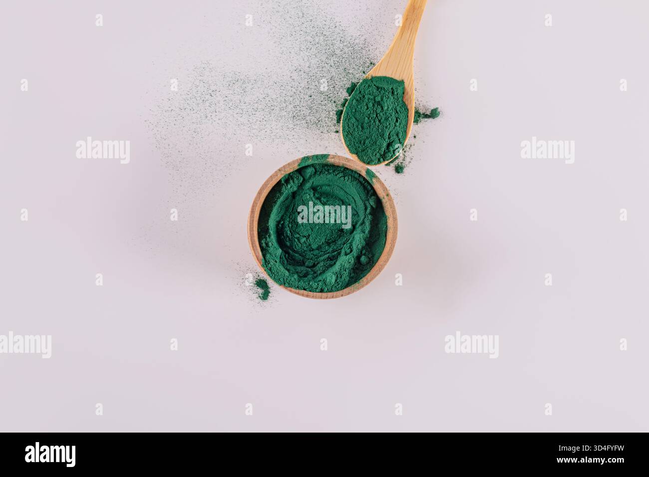 bol en bois et cuillère remplis de poudre de spiruline naturelle. superaliment bleu, vert. Détox. Supplément organique de perte de poids. vue de dessus. fond blanc Banque D'Images