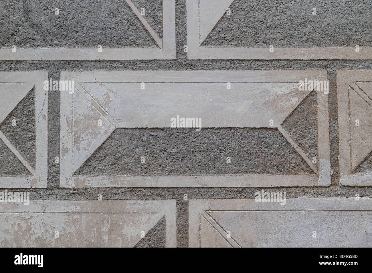 Un mur extérieur historique peint avec des blocs de pierre jaunâtre et des motifs géométriques sombres. Texture architecturale. Architecture paysagère. Républicain tchèque Banque D'Images