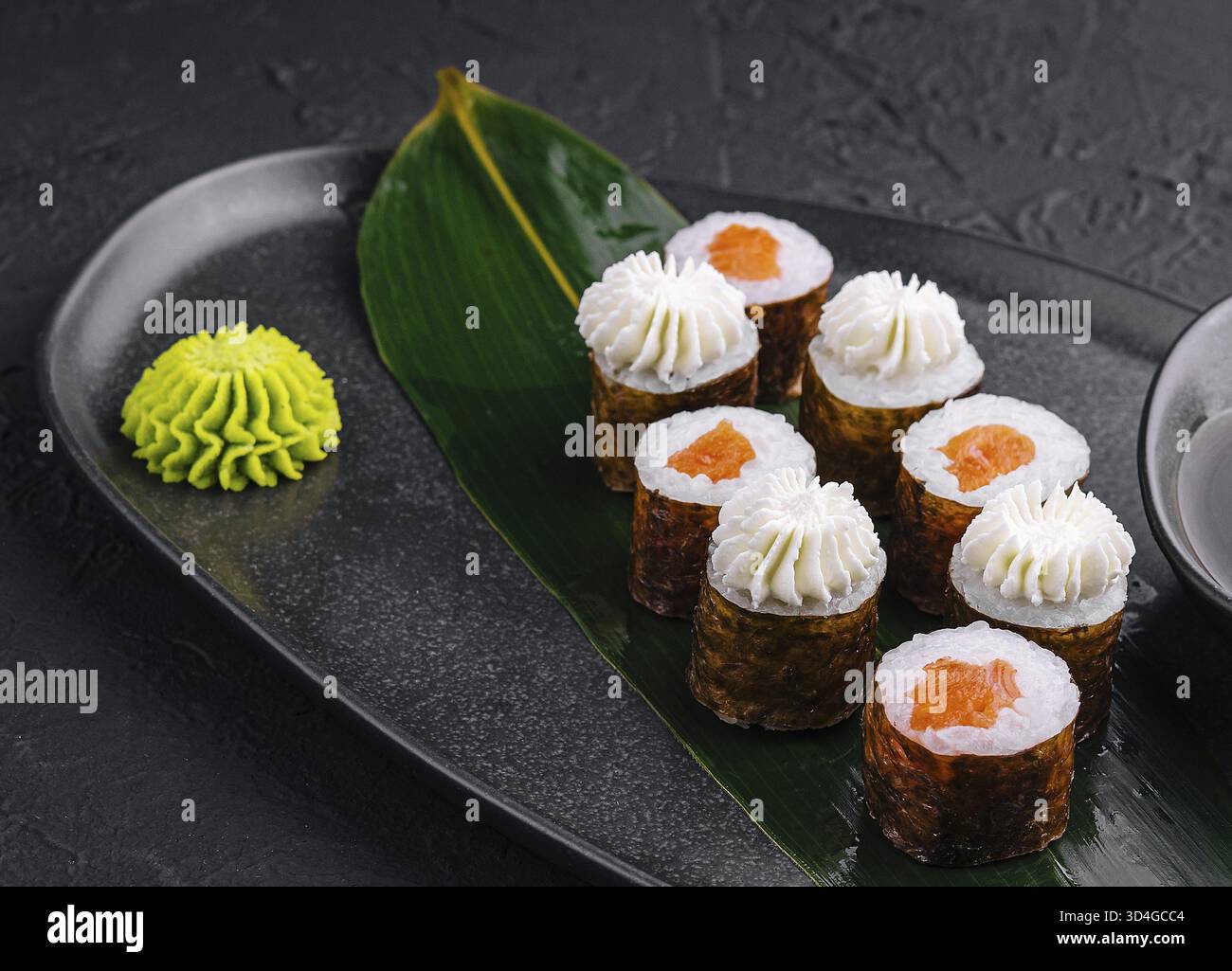 Nourriture, sushi avec fromage Philadelphie et saumon sur assiette asiatique noire Banque D'Images