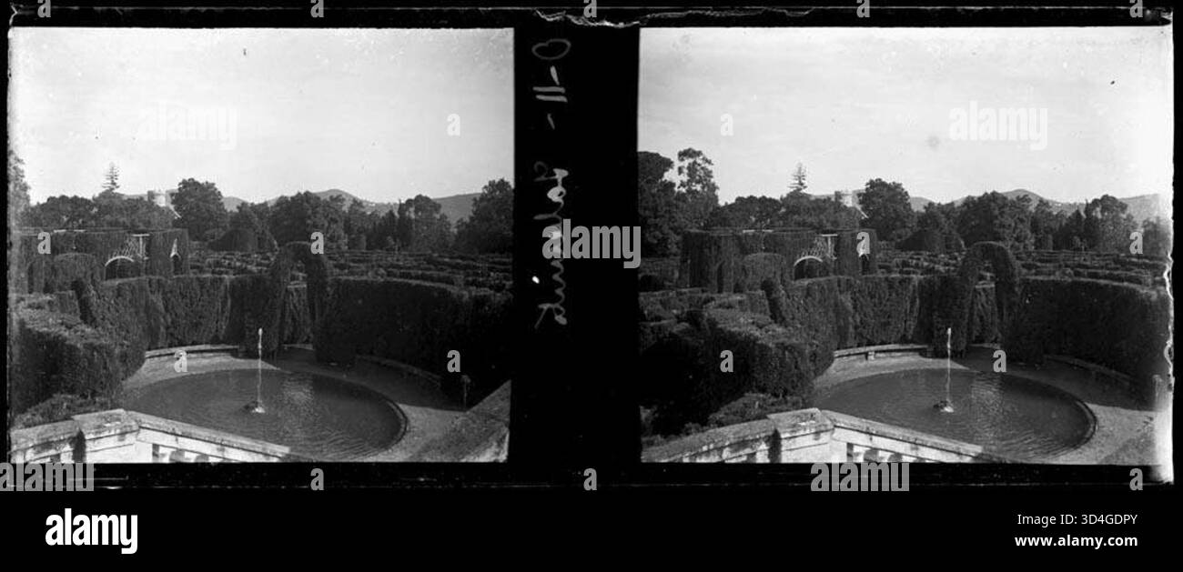Capturée entre 1899 et 1910, cette image montre une fontaine et un labyrinthe avec des montagnes en arrière-plan, créant un paysage pittoresque et serein. Banque D'Images