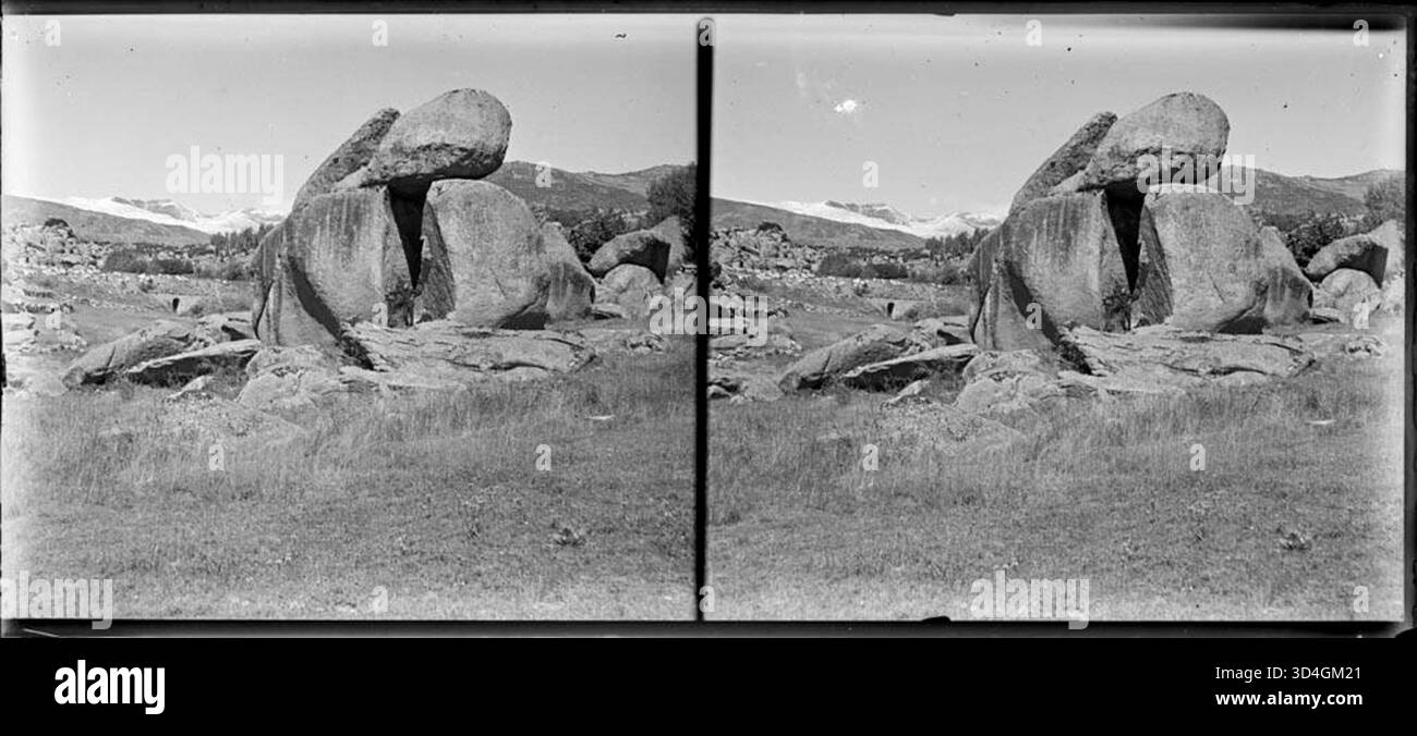 Une vallée avec des rochers au premier plan et des montagnes enneigées en arrière-plan, photographiée par Josep Domènech i Sàbat entre 1922 et 1934. Ce paysage capture la grandeur du monde naturel. Banque D'Images