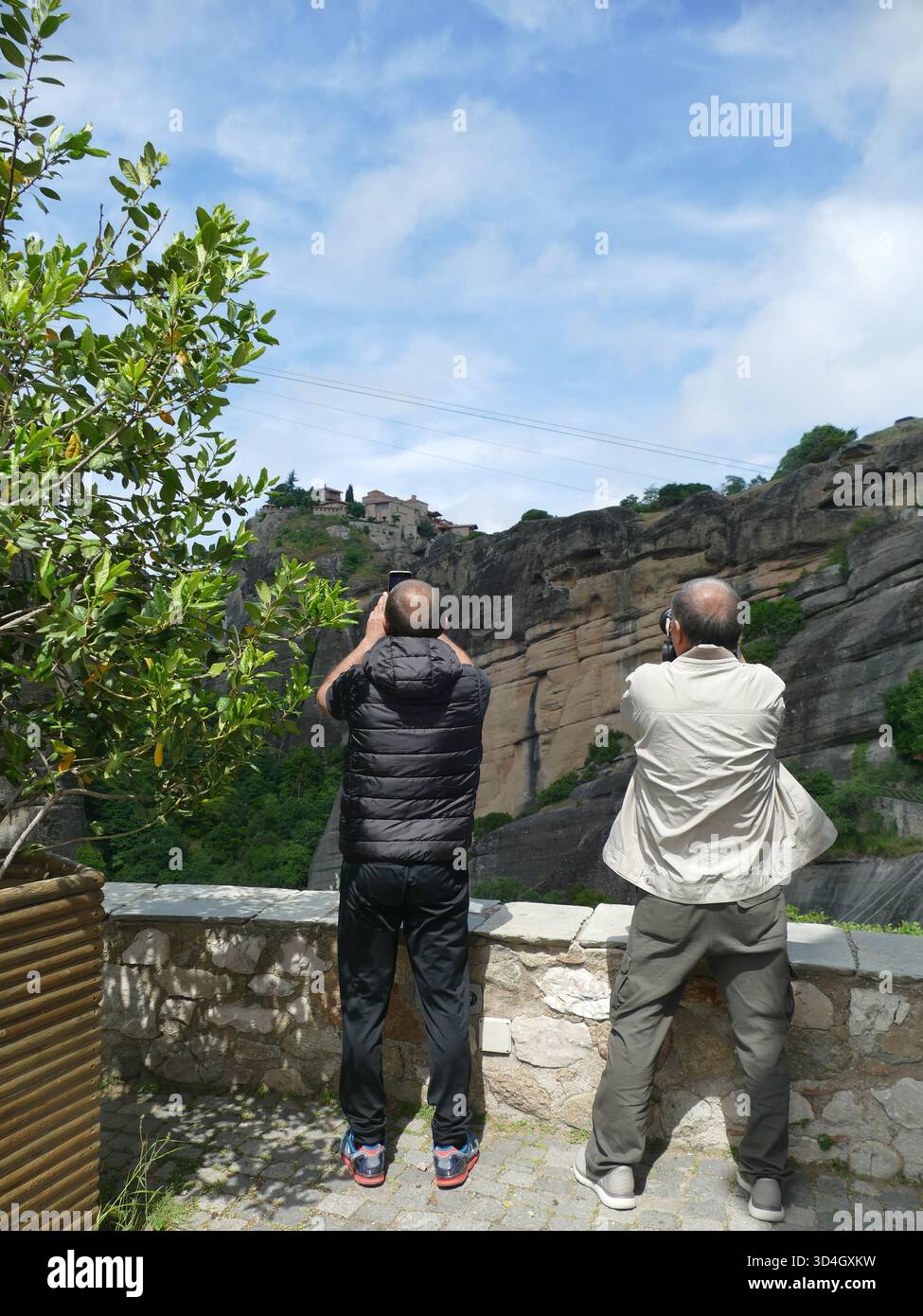 MÉTÉORES, GRÈCE - 11 MAI 2025 - touristes photographiant le monastère Saint Nicolas Anapafsas, monument de l'UNESCO perché sur le pinacle rocheux de Météo Banque D'Images